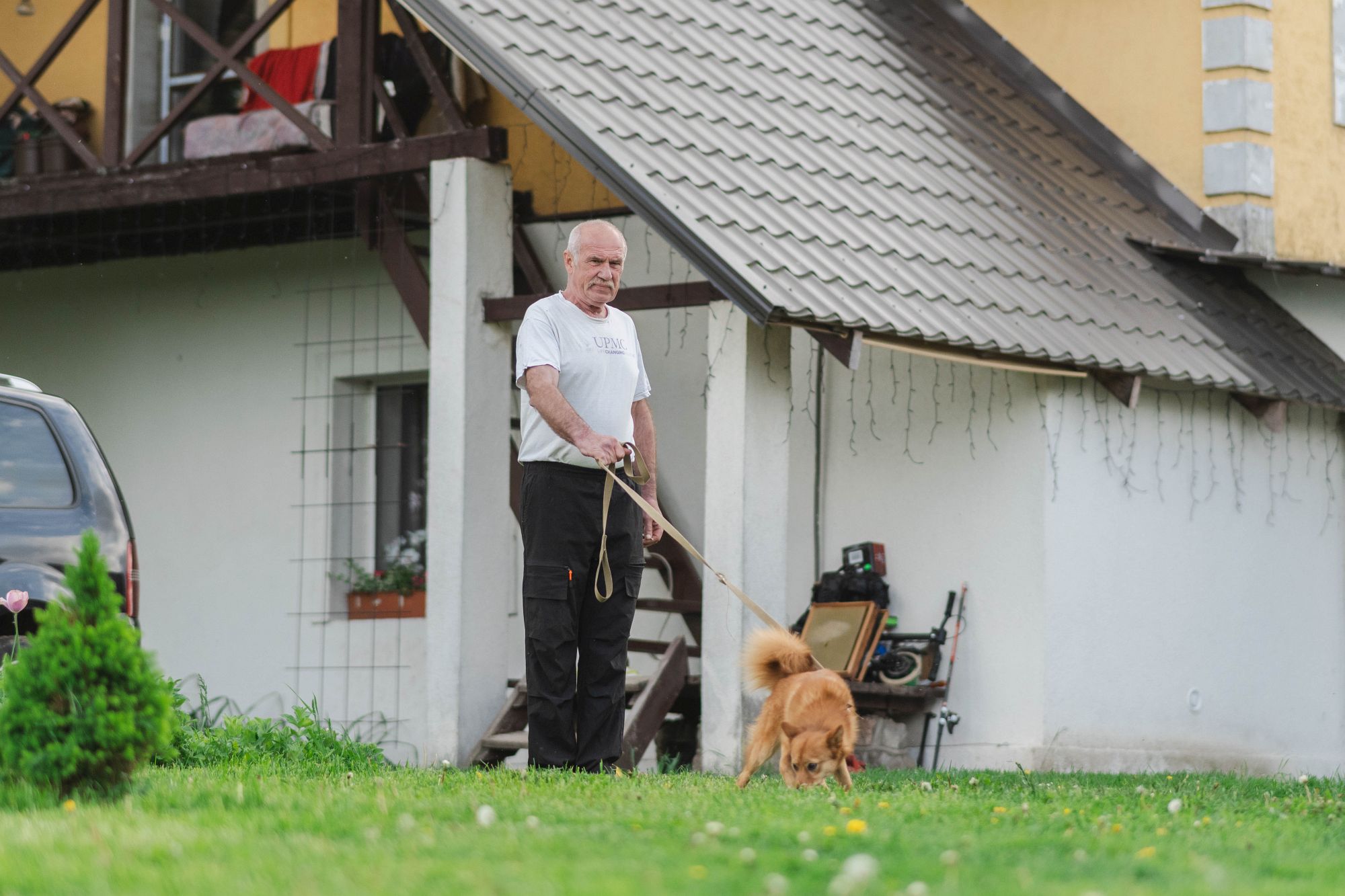 Portrets: Ainārs Lociks pie mājas ar suni