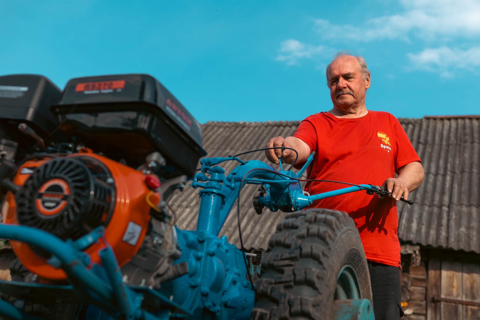 Aleksandrs blakus tehnikai, kas līdzinās motoblokam vai pašdarinātam darba agregātam.