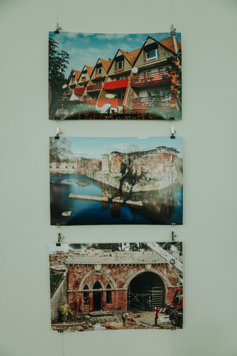 Darbi, kuru autore ir Inesa Norkarkle, tostarp arī šī ēka, redzami pirmajā fotogrāfijā augšā. Fotoizstāde Daugavpils Krievu kultūras centrā, 2025. gada 19. septembris. Foto: Irina Maskaļenko.