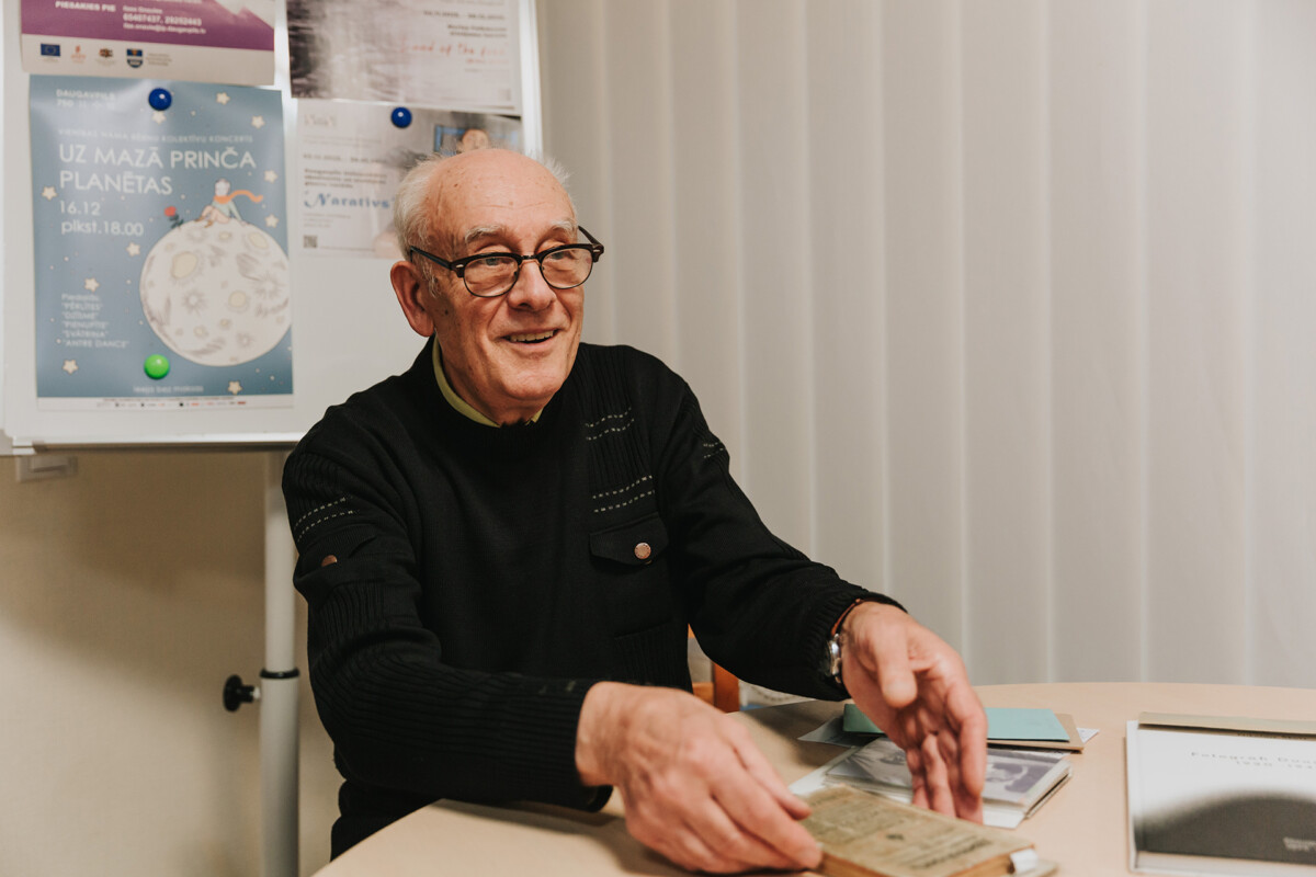 Nikolajs Škuts uz interviju ieradās ar koferi, kurā bija viņa grāmata un eksponāti no personīgās kolekcijas. Foto: Irina Maskalenko (Daugavpils, 2025. gada 4. decembris)